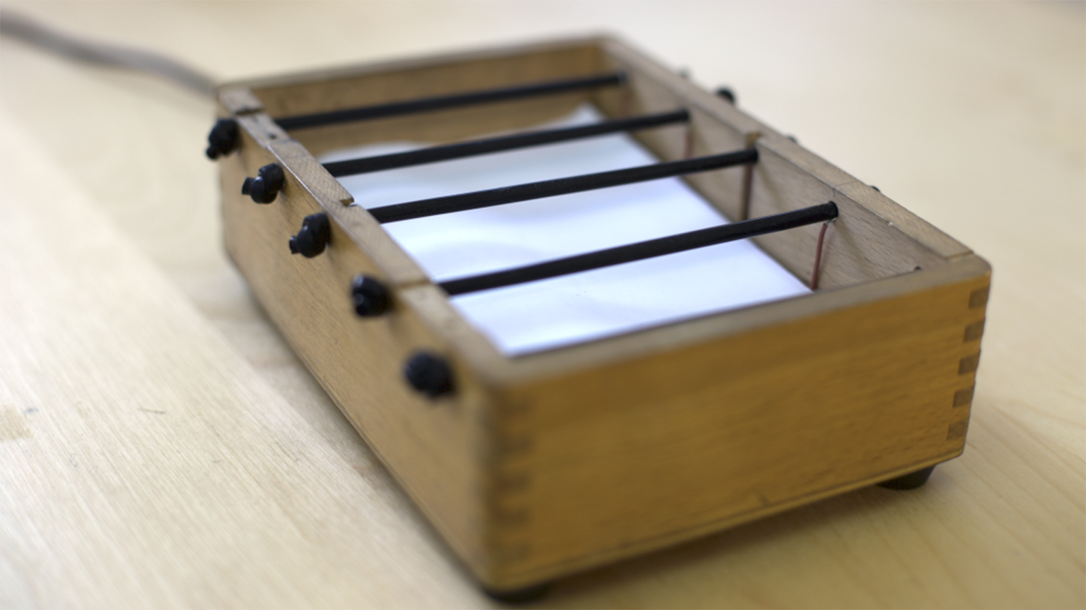 The Stretchi, a small box that can be played with one hand by moving the strings in the instrument.