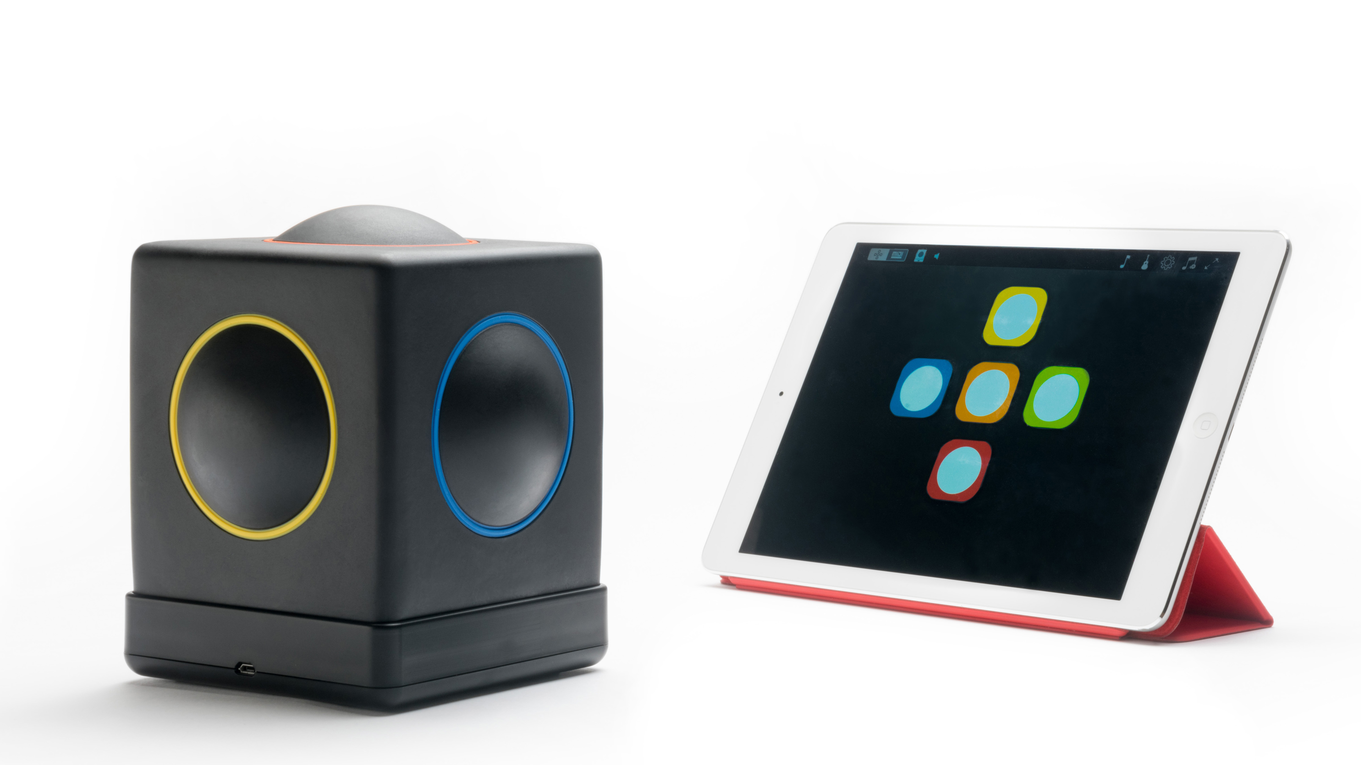 The Skoog, a boxlike instrument with panels on each side, sitting next to an iPad.