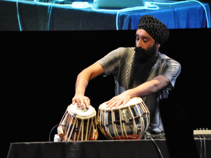 A man playing the Tablix, a modified pair of drums.
