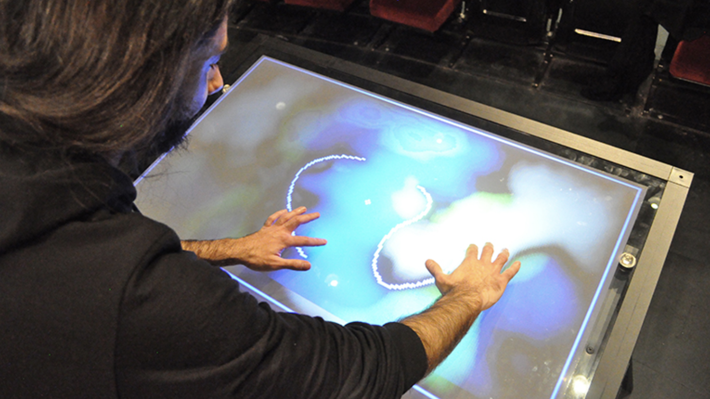 Man interacting with touchscreen display with musical capabilities. 